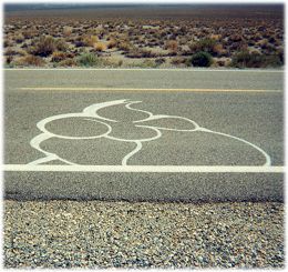 Unexplained art, in white paint, on the road surface