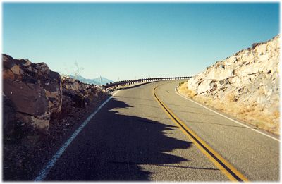 Highway with no shoulder inside the guardrail and a dropoff just outside the guardrail
