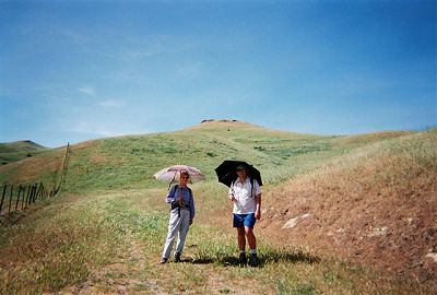 two hikers in short grasses on a ridge top