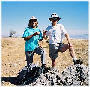 Dinesh and John on the summit, each with a glass of wine