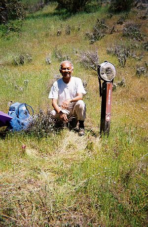 Dinesh next to a signpost with an old canteen fastened to it