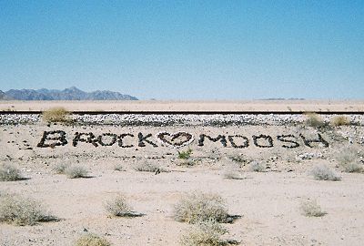 Rock art along railroad tracks reading BROCK (heart) MOOSH