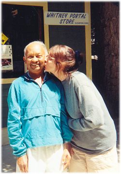 Dinesh being kissed on the cheek by a passer-by in front of the Whitney Portal store