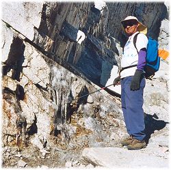 Dinesh pointing to ice on the rock adjacent to the trail above Trail Camp