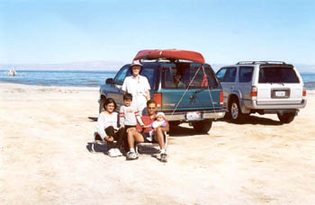 Joy with Alpa and her family on a broad sand beach