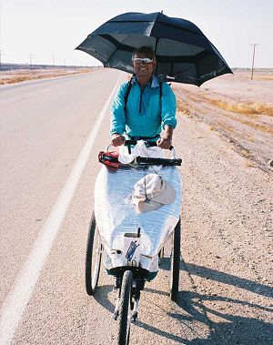 Dinesh pushing the jogger, hat fastened to the front