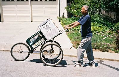 Dinesh testing an early arrangement of items on the three-wheeled baby jogger frame.